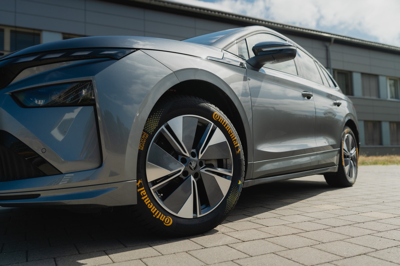Continental concept tyre with yellow ZEvRA sidewall lettering fitted to a grey electric car, front three-quarter close-up of the wheel