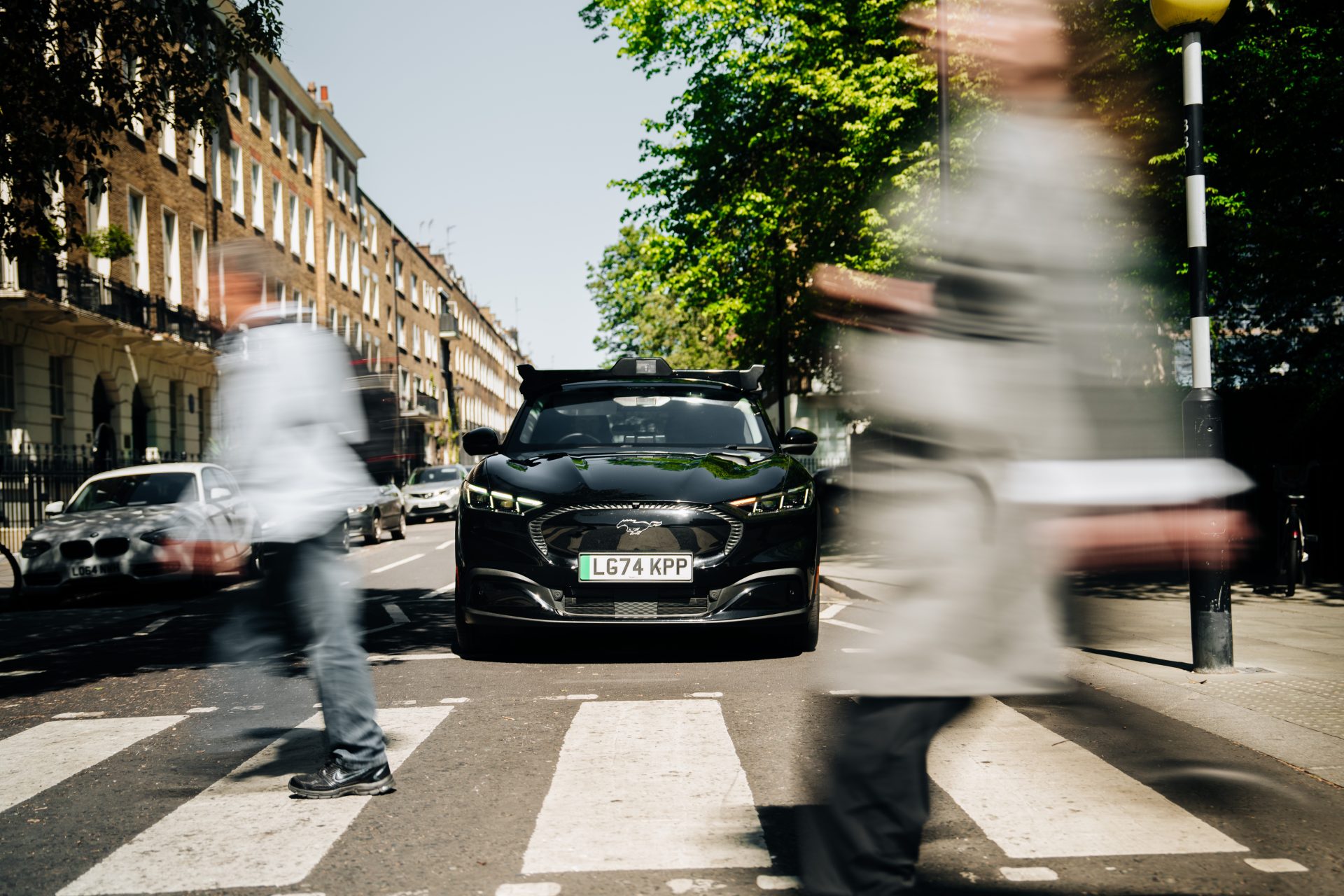Wayve AI Driver autonomous all-electric Ford Mustang Mach-E stopped at a zebra crossing on a London street